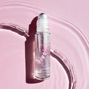 Parfumul roll-on Inuwet Pivoine cu sclipici, pe fundal roz-liliachiu