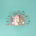 Geanta Unicorn din catifea alături de agrafe cu stele și inimi, pe fundal turcoaz