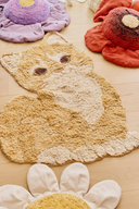 Covorul Ginger the Cat pe podea, lângă flori