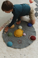 Copil așezând racheta pe suprafața cu orbite a setului Solar System