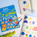 Caietul cu 300 de stickere Les Toupitis, alături de coli ilustrate, creioane și foarfecă