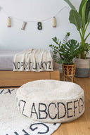Puful ABC Natural Black lângă pat și covor