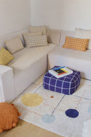 Puful Geo Block Navy Blue lângă o canapea