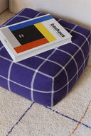 Detaliu al suprafeței pufului Geo Block Navy Blue, cu o carte deasupra